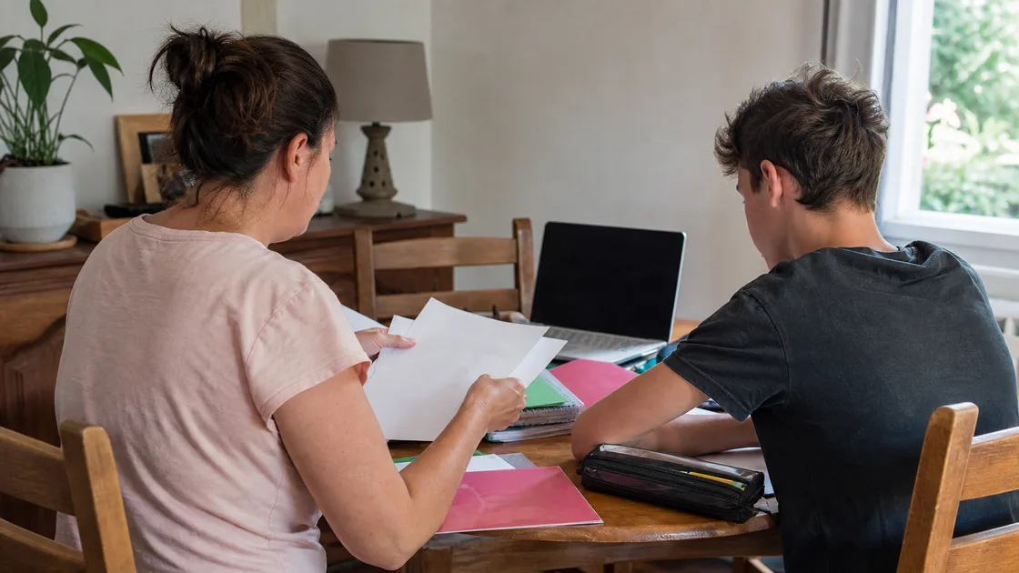 Un parent et un adolescent préparent les démarches de rentrée à la maison