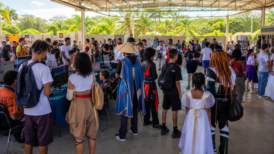 Des familles et des adolescents découvrent des espaces de cosplay et de jeux vidéo lors d'une convention tropicale