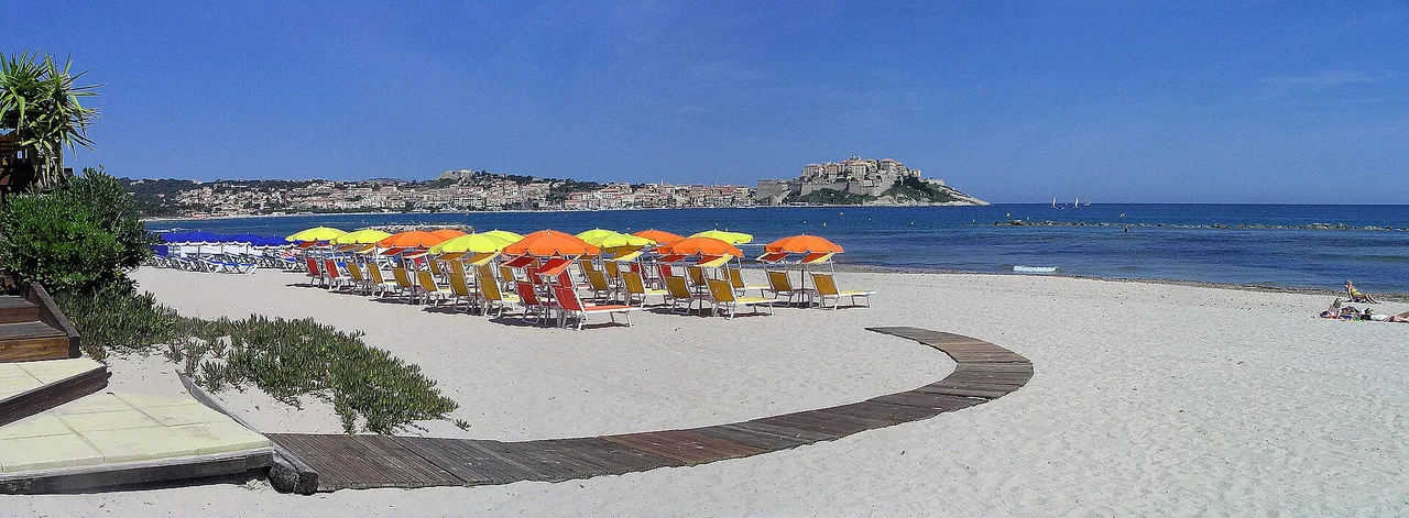 Plage de la Pinède à Calvi avec sa longue bande de sable bordant la baie