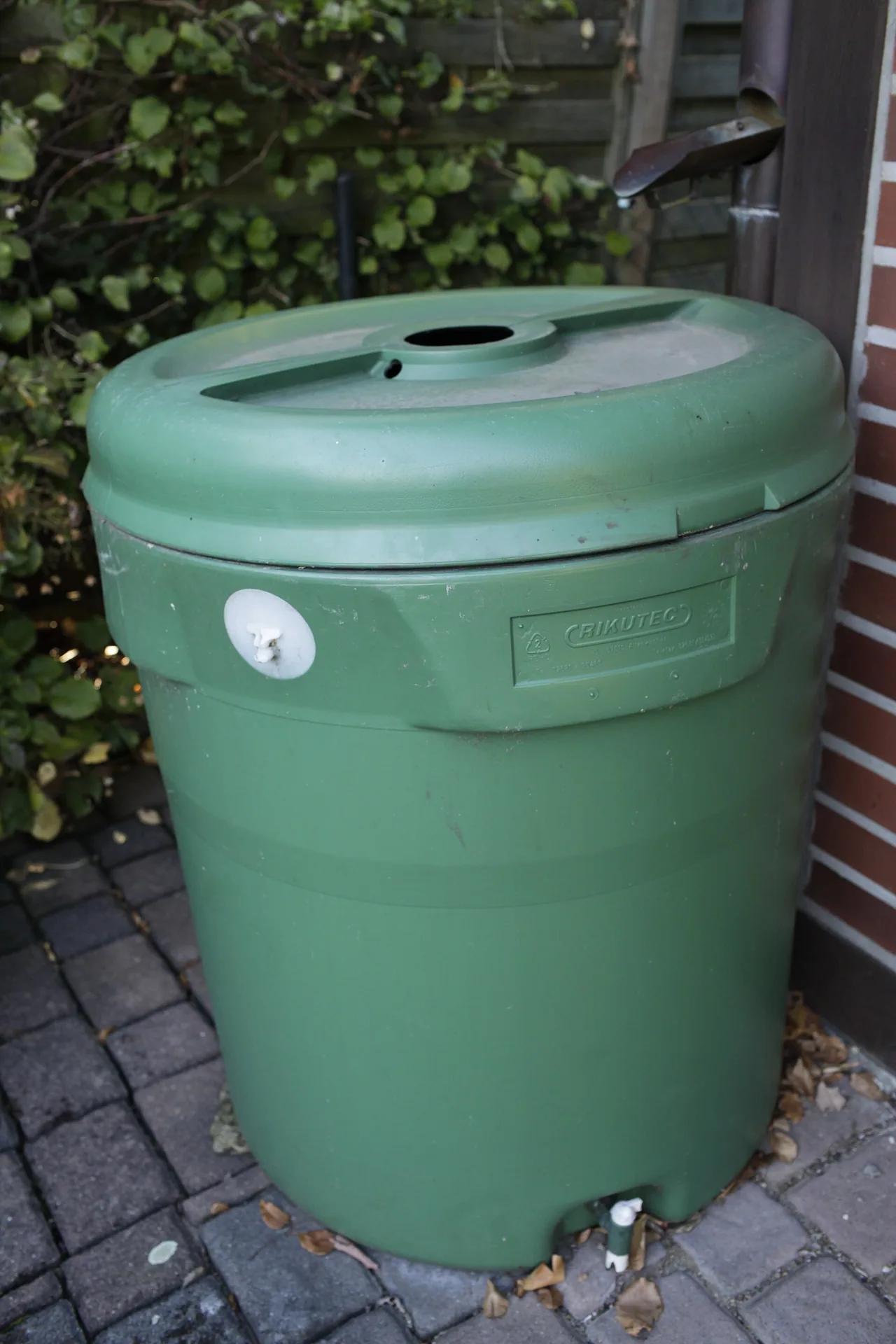 Cuve verte d’environ 200 litres utilisée pour récupérer l’eau de pluie