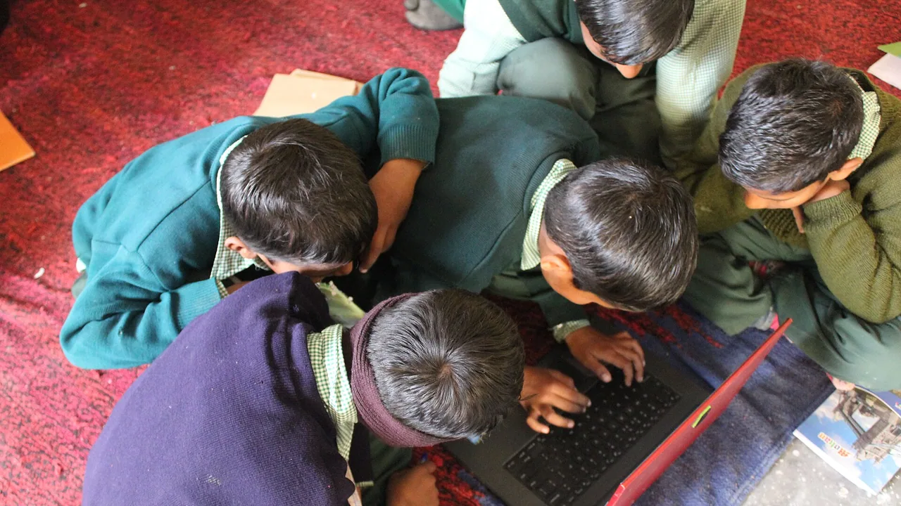 Enfants utilisant un ordinateur portable, illustration des services numériques liés à la scolarité