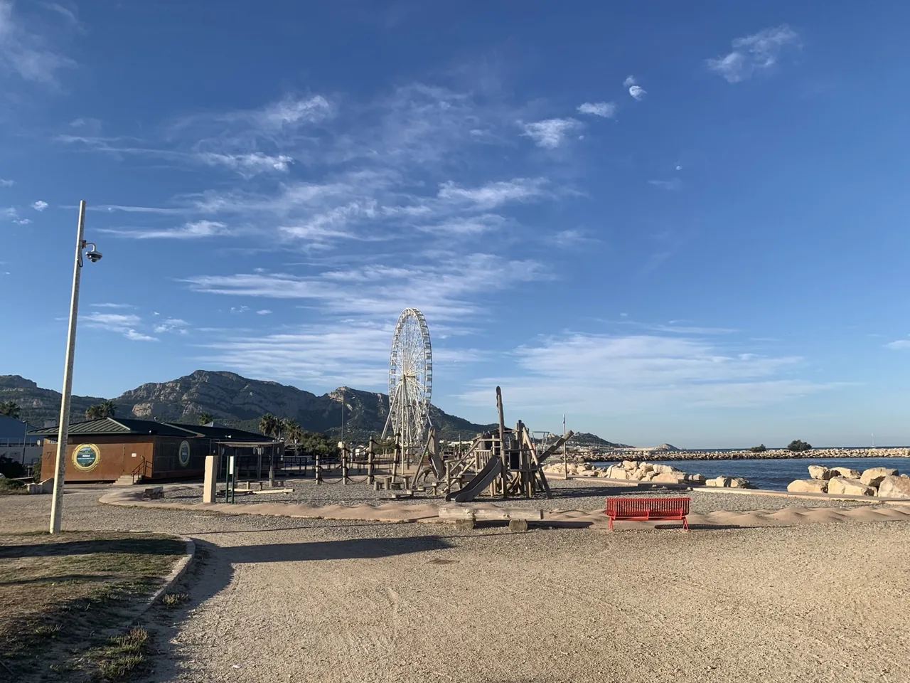 Aire de jeux de l'Escale Borély avec la grande roue et le relief marseillais en arrière-plan