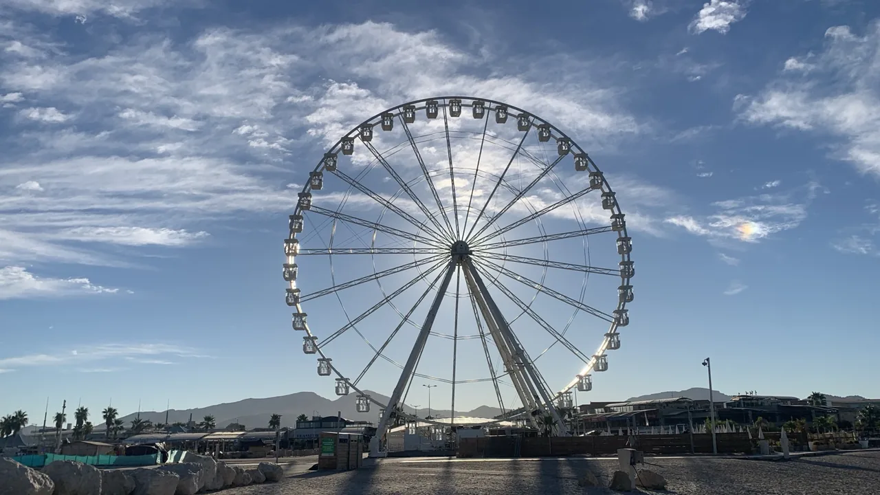 Grande roue de l'Escale Borély avec le soleil derrière sur le littoral marseillais