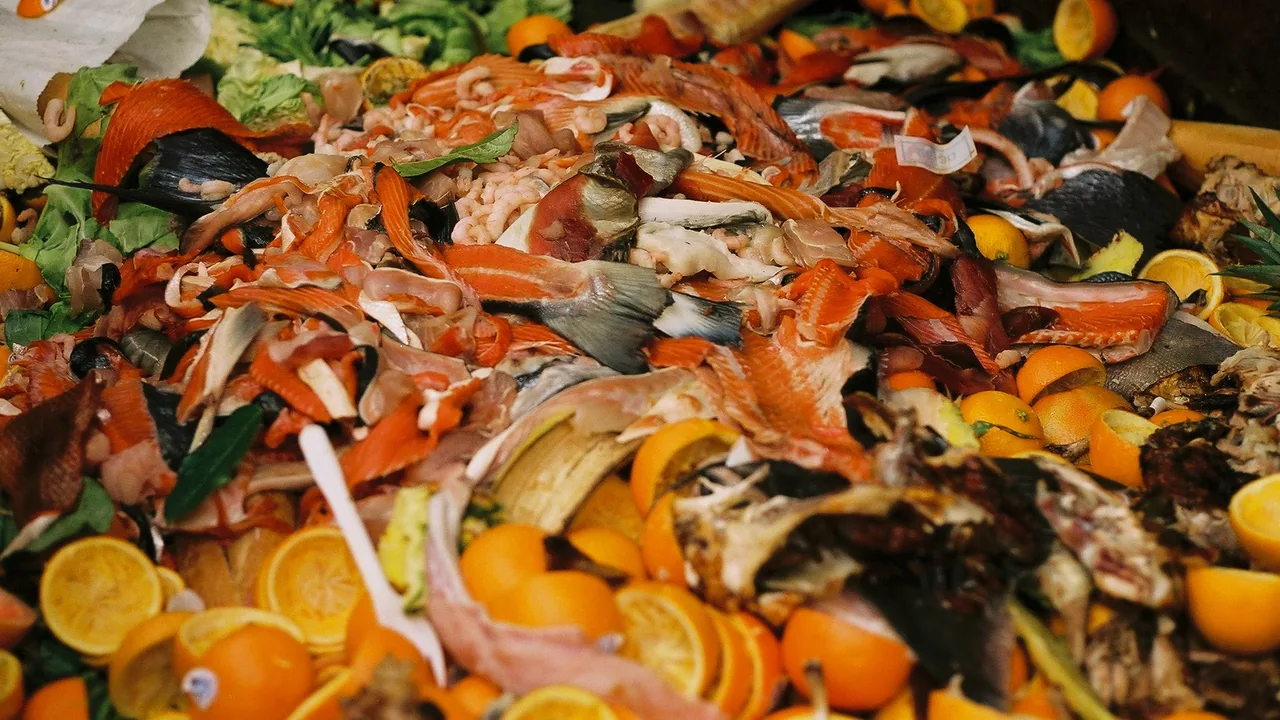 Denrées alimentaires jetées dans un conteneur de marché, illustrant le gaspillage alimentaire
