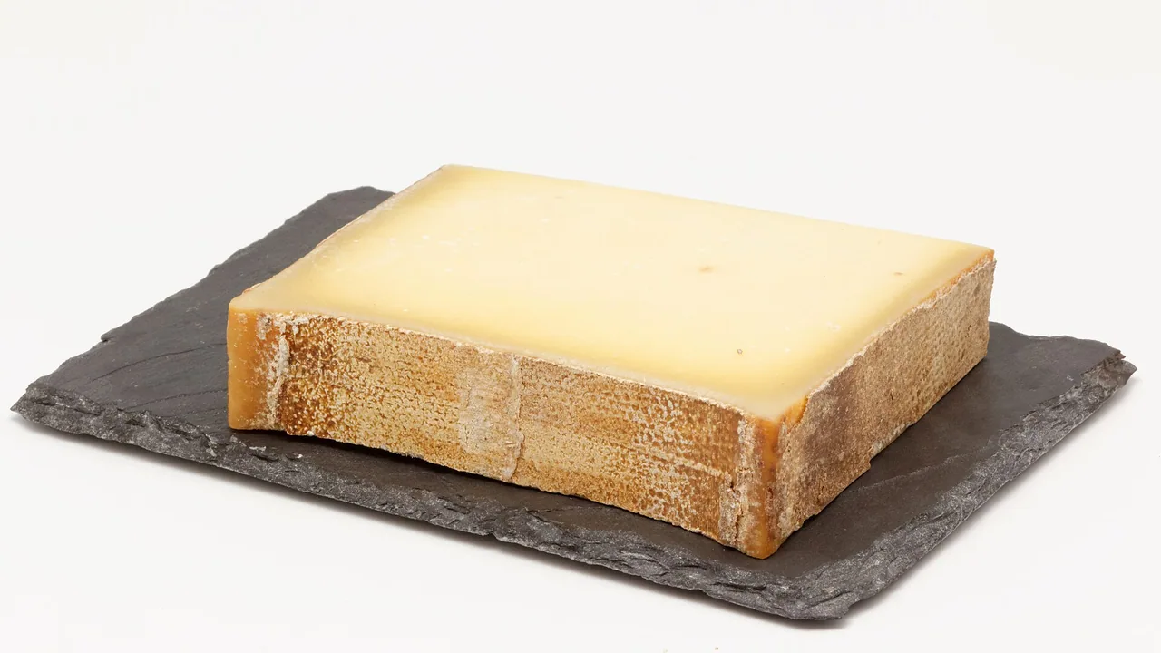 Morceau de fromage Beaufort posé sur une ardoise