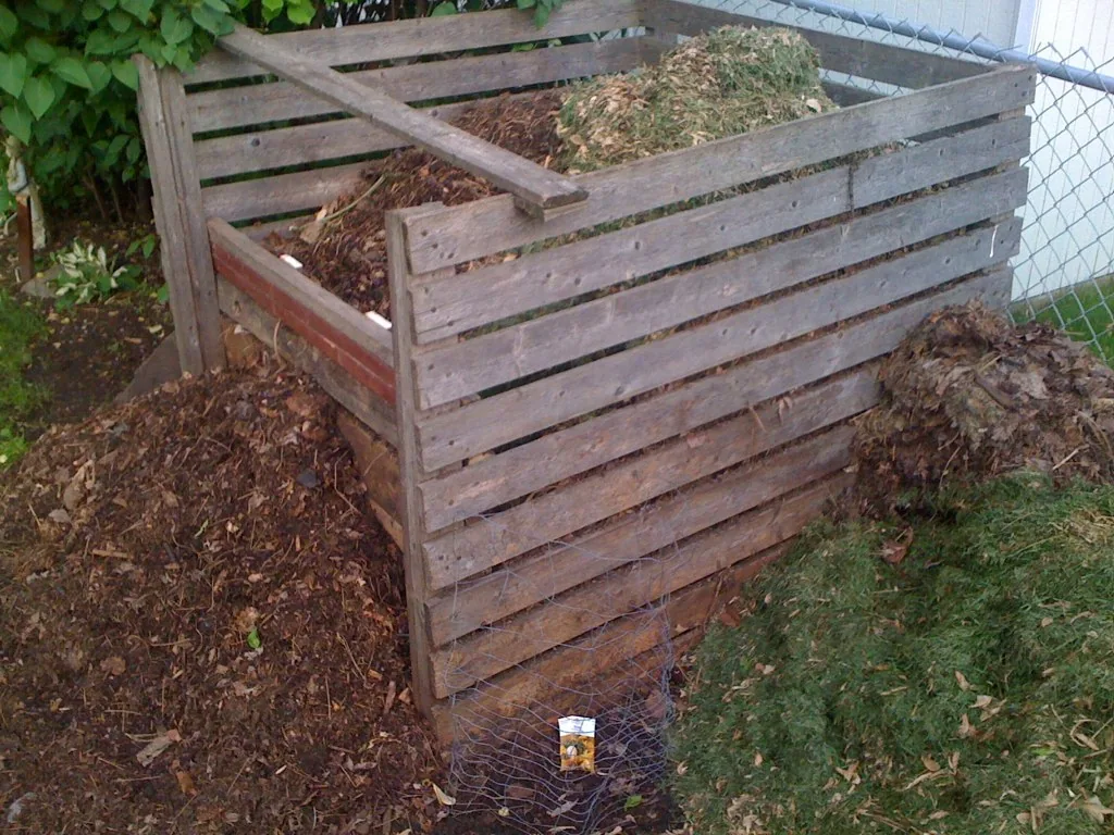 Composteur individuel en bois installé dans un jardin, photographie illustrative