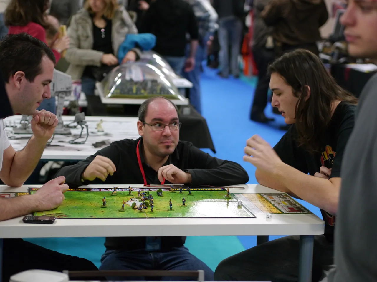 Trois participants autour d'un jeu de plateau lors du Festival des Jeux de Cannes en 2012