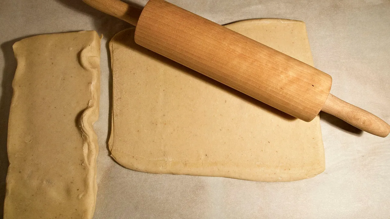 Pâte feuilletée étalée avec un rouleau à pâtisserie, pour illustrer le feuilletage