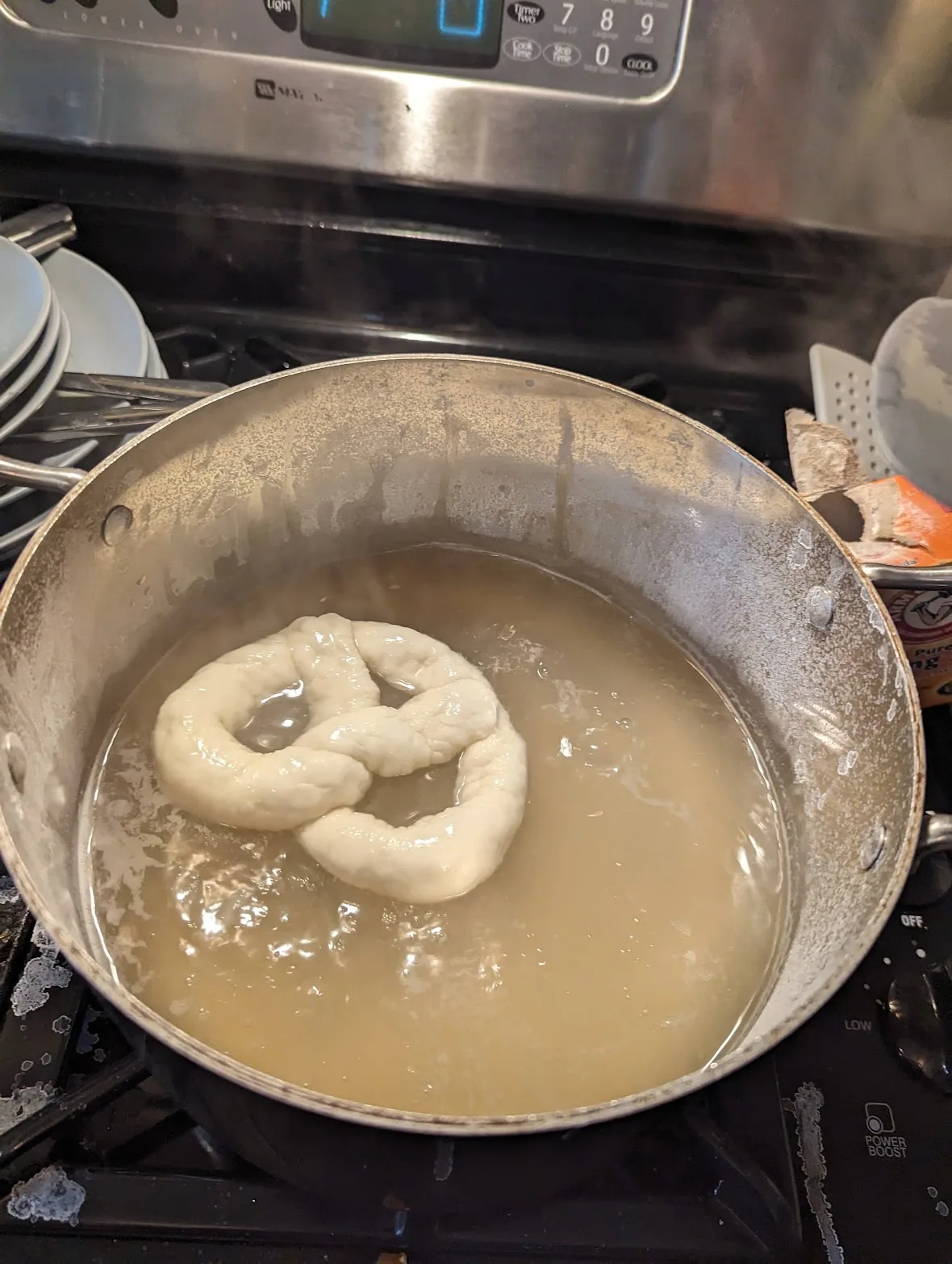 Bretzel en pâte plongé dans de l'eau bicarbonatée pendant sa préparation