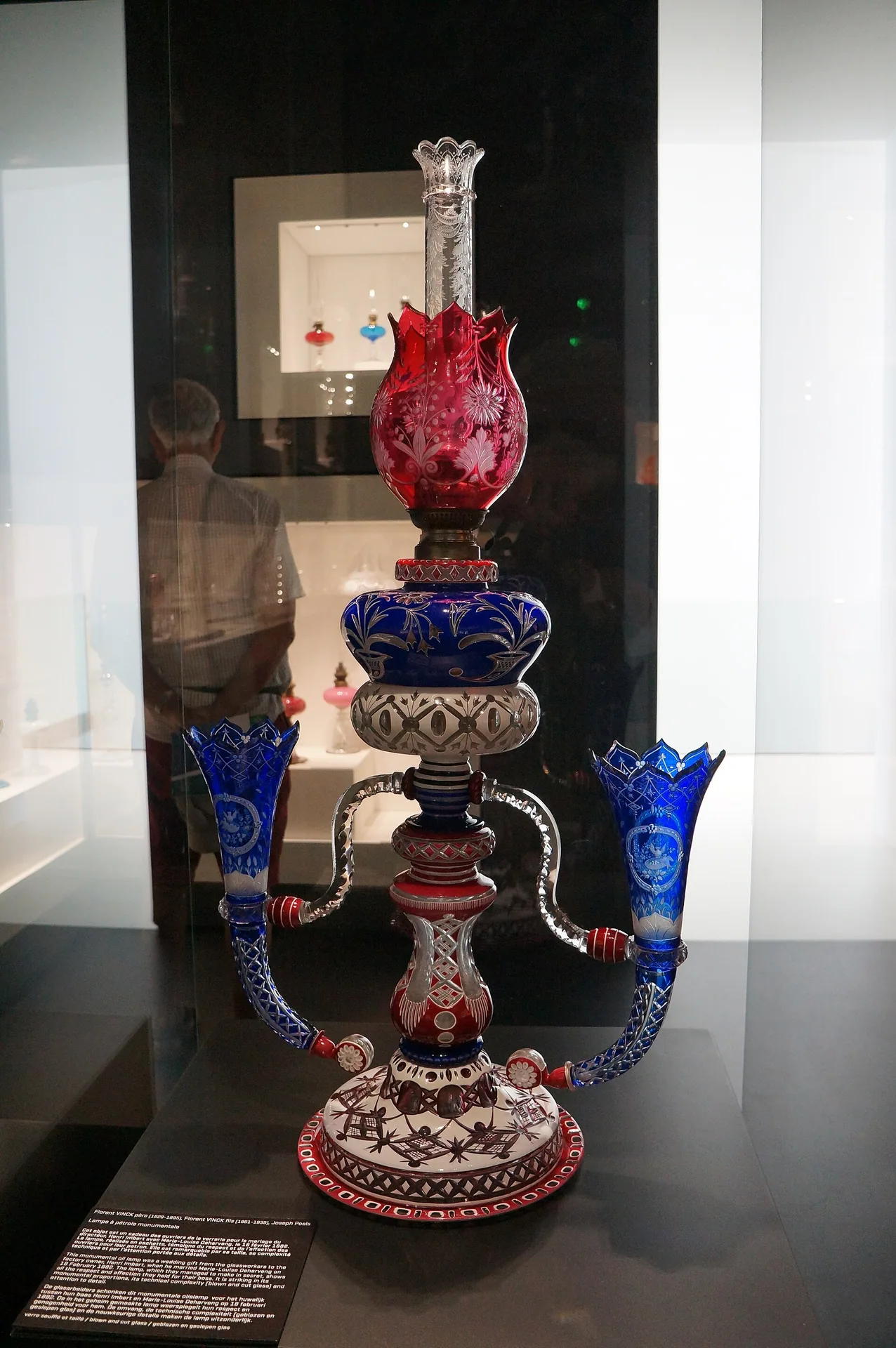 Lampe à pétrole en verre soufflé, taillé et gravé, offerte en 1882 et exposée au musée du verre de Sars-Poteries.