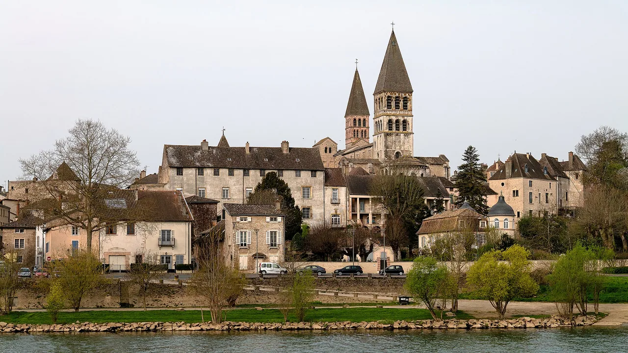 Abbaye Saint-Philibert, toits de Tournus et berges de la Saône photographiés depuis l'autre rive en mars 2022.
