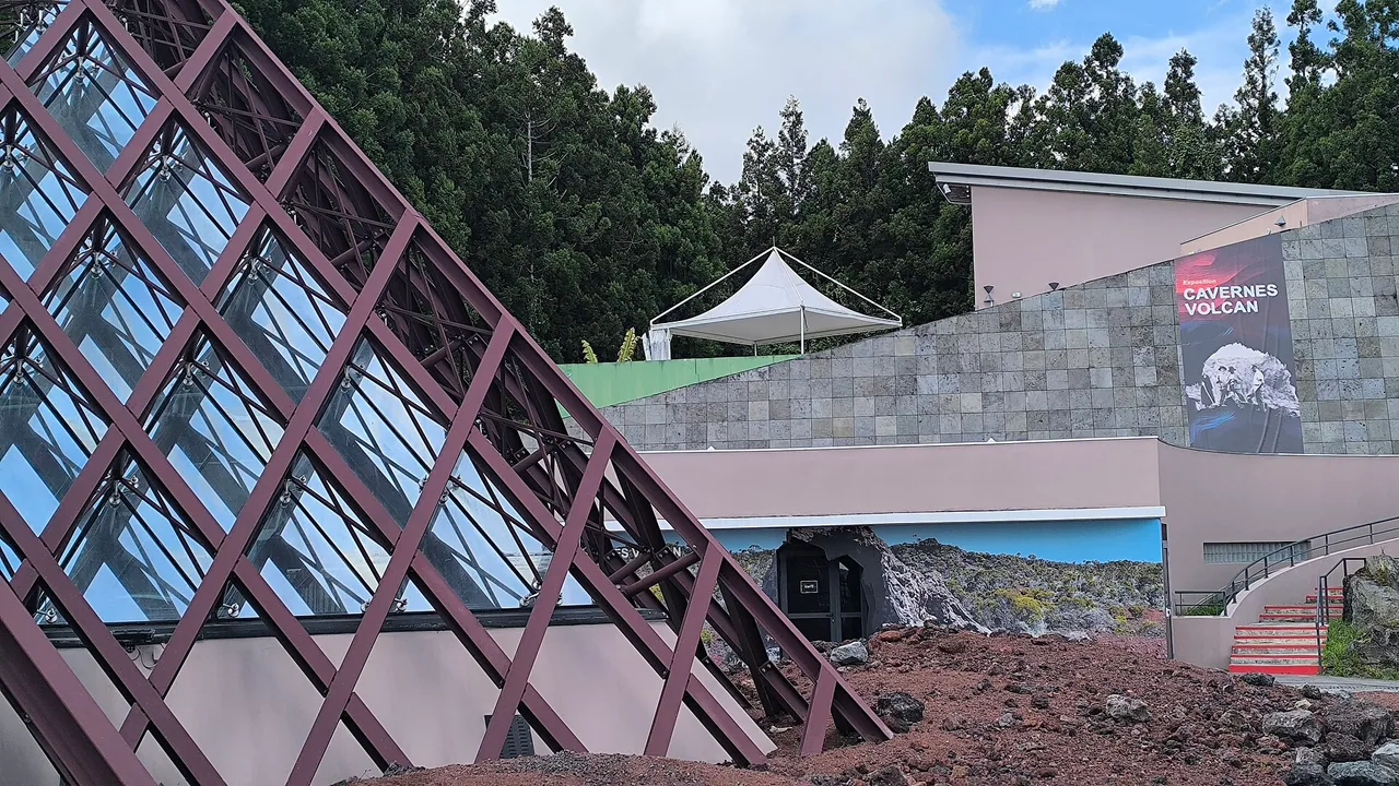 Structure en verre et acier devant la façade de la Cité du Volcan à Bourg-Murat, La Réunion, en mars 2026